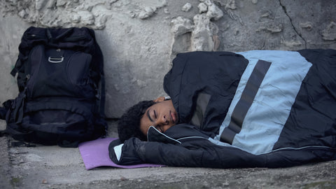 Homeless man sleeping outdoor in a sleeping bag
